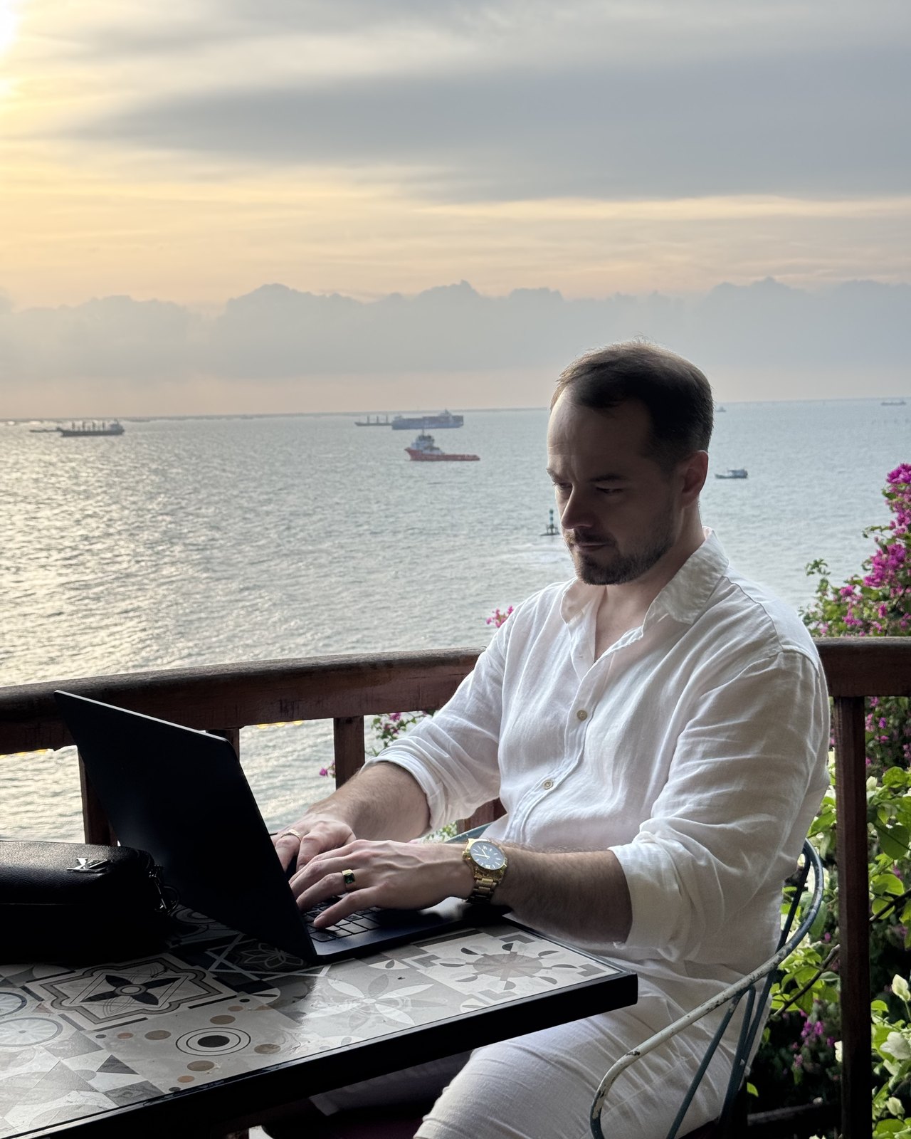 Blake working from a balcony over the sea in Vietnam